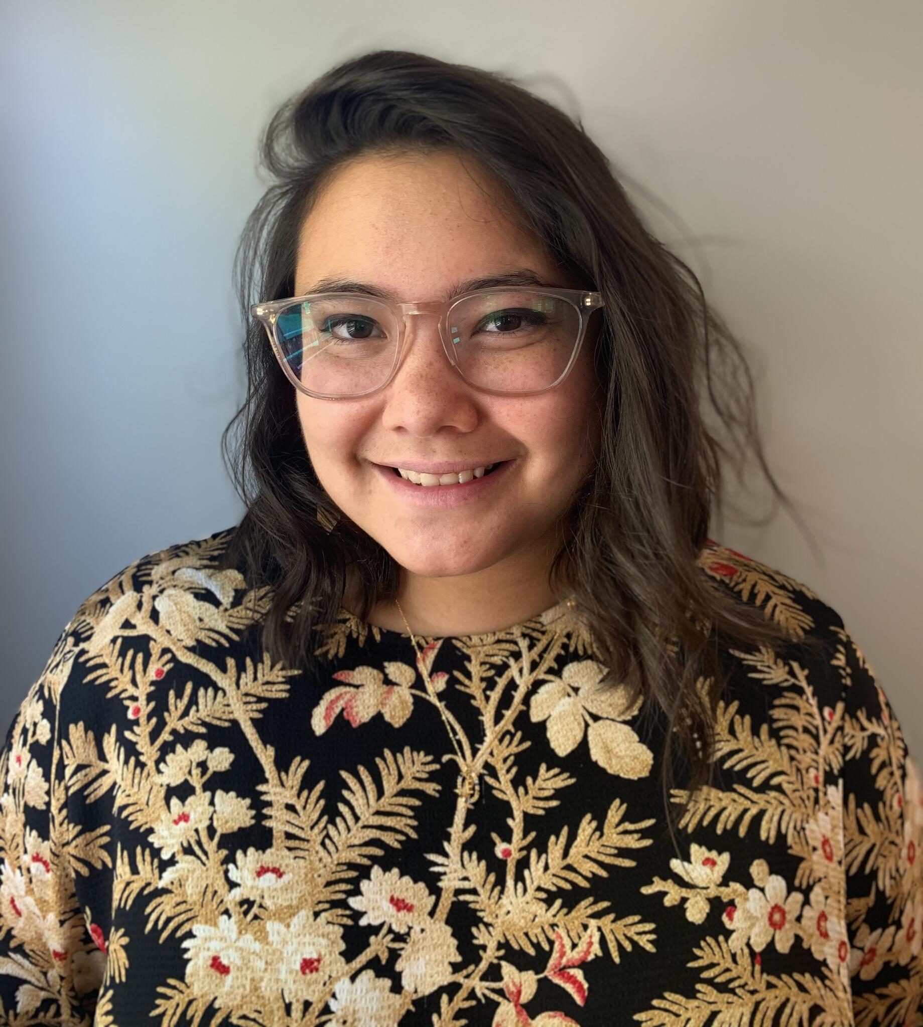 A woman wearing glasses smiling