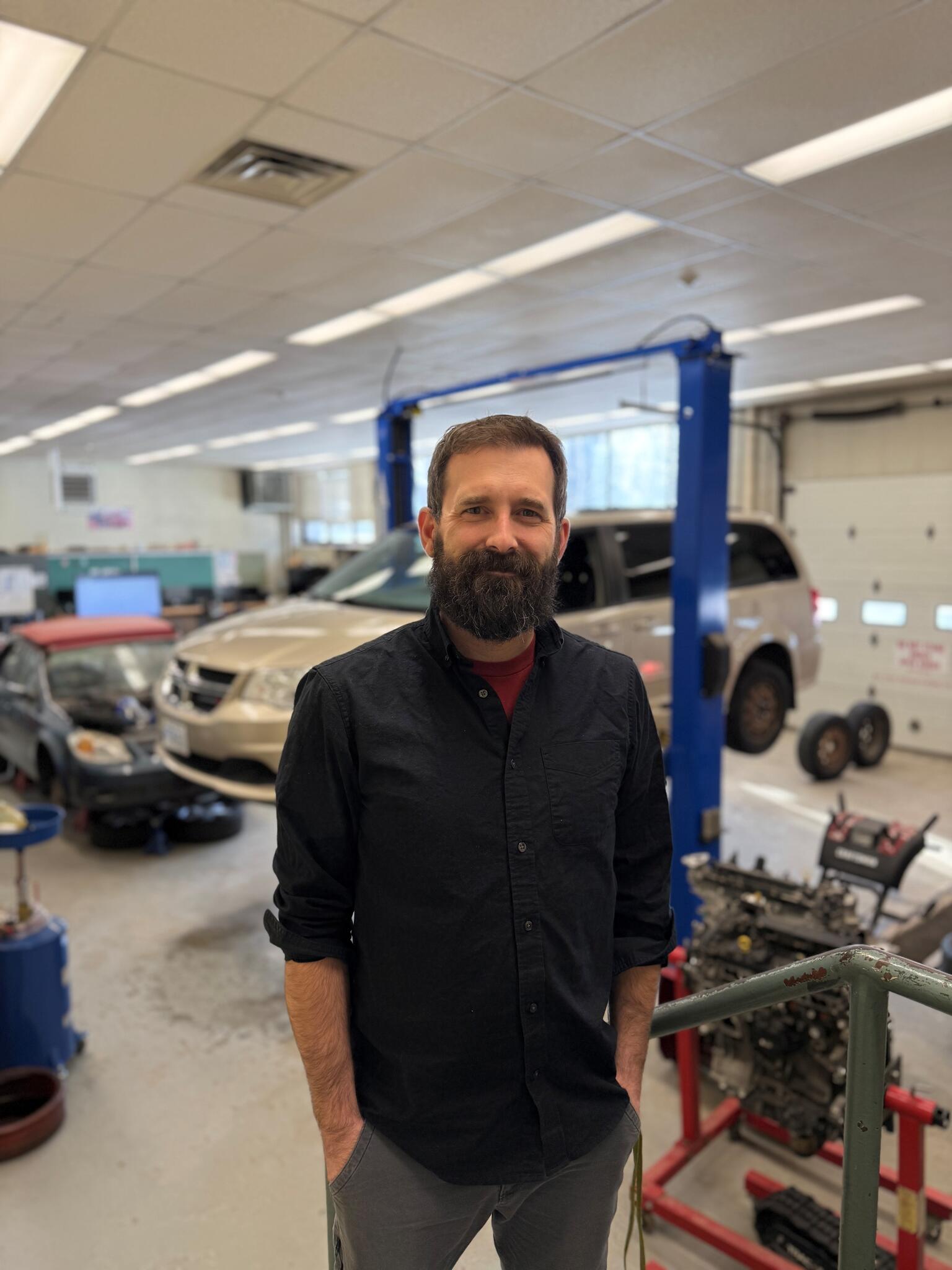 A man stands in front of a garage